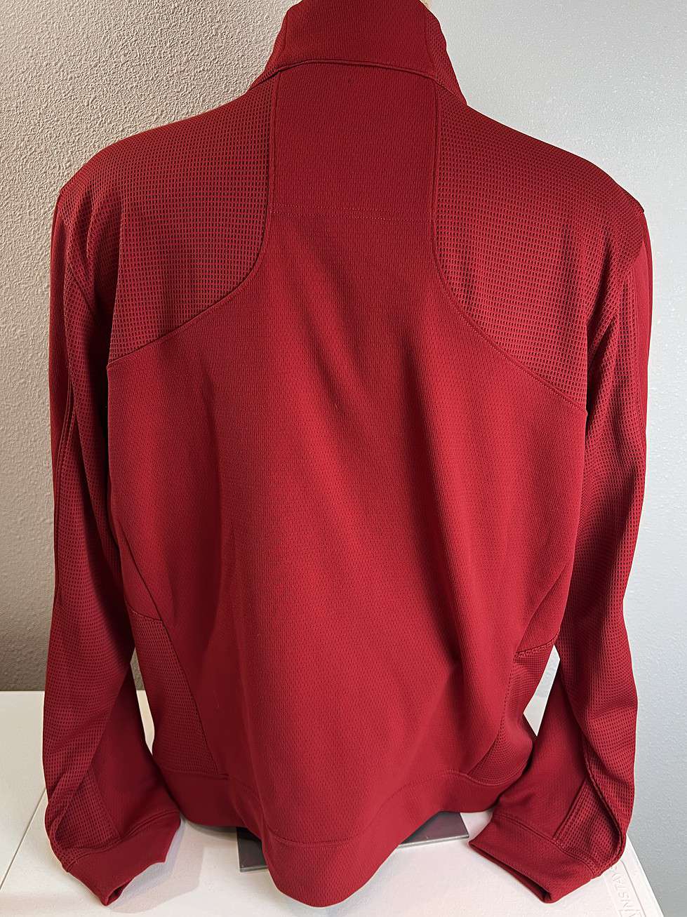 Back view of a red Philadelphia Phillies quarter-zip pullover showing a smooth, clean design with textured shoulder panels.