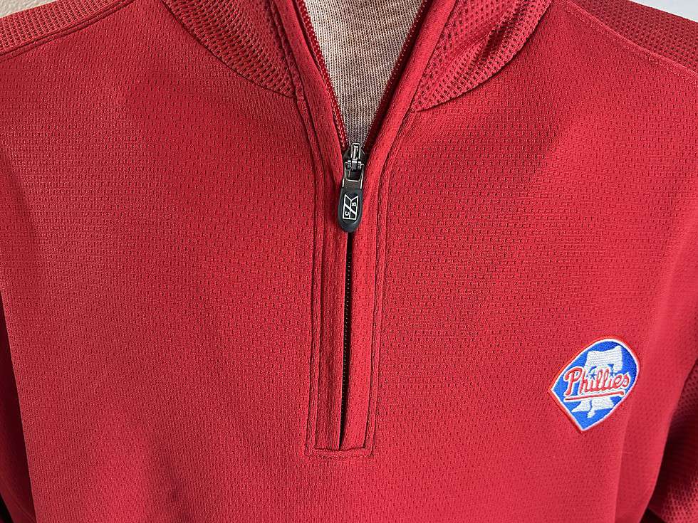 Close-up of the Philadelphia Phillies logo on a red quarter-zip pullover, showcasing the team's iconic blue and white emblem.