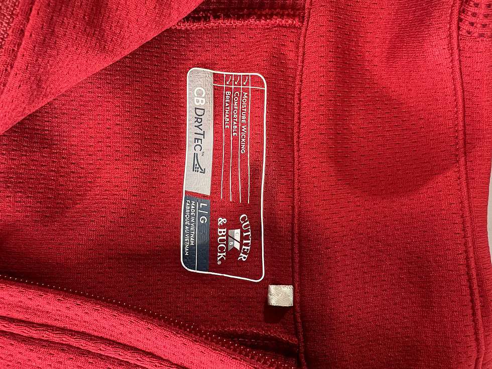 Cutter & Buck brand label on a red quarter-zip pullover indicating the fabric technology, CB DryTec, size Large, and care instructions.