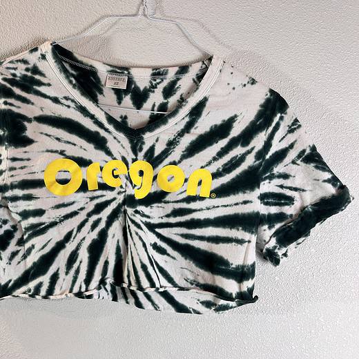 Stylish cropped t-shirt with a black and white tie-dye design, featuring bold yellow 'Oregon' lettering across the chest.