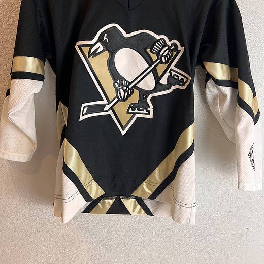 Classic Pittsburgh Penguins youth hockey jersey in black with white and gold accents, featuring the team's logo on the front and a V-neck design