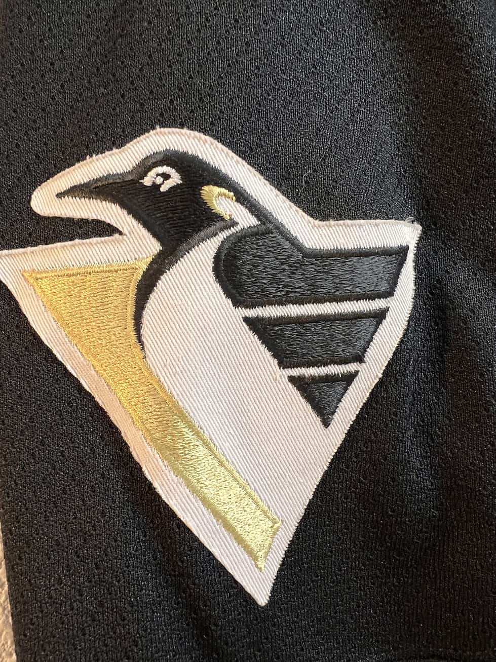 Close-up of the shoulder patch on the Pittsburgh Penguins jersey, with the alternate 'flying penguin' logo.