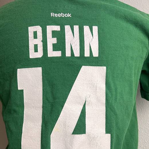 Back view of a child's green Reebok t-shirt with 'BENN 14' in large white letters. Details show cracking in print and small yellow spot in number 4.