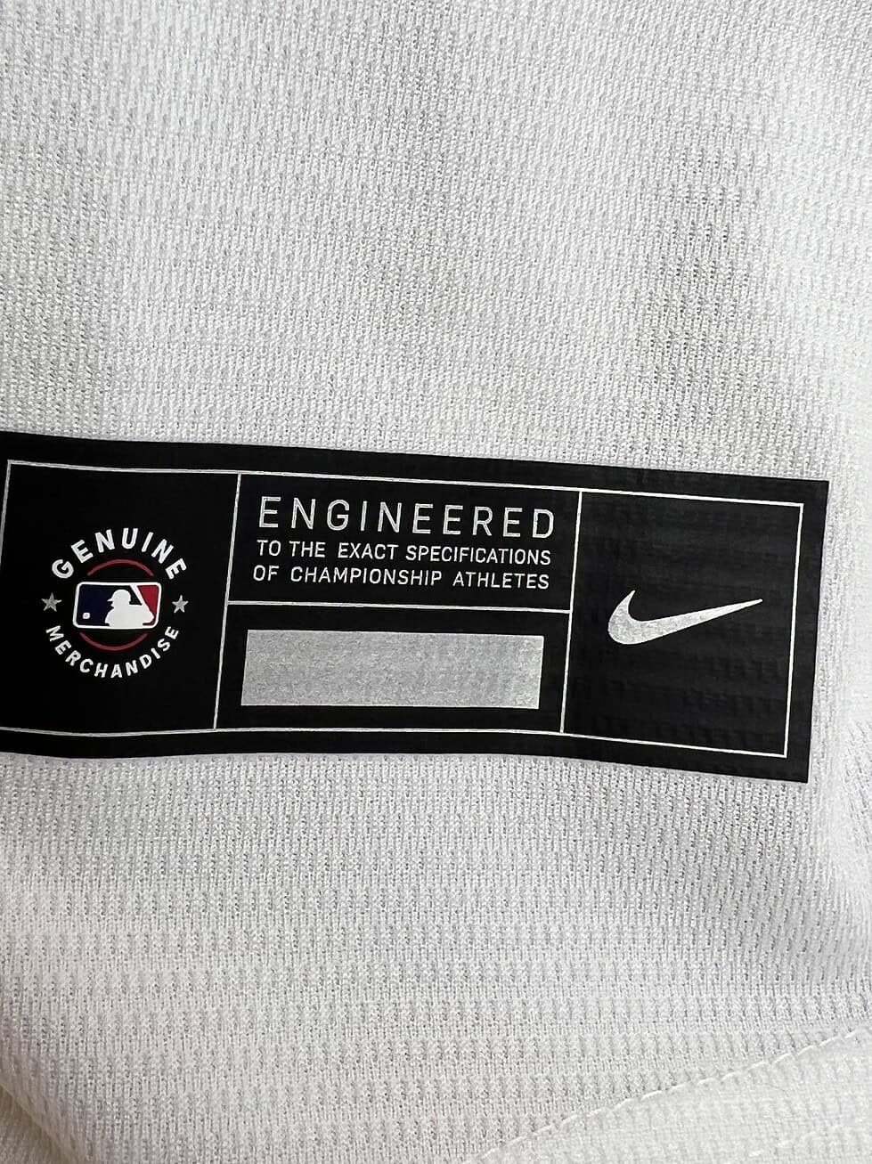 Detail of the Nike tag on the Astros jersey with text ‘Engineered to the exact specifications of championship athletes’.