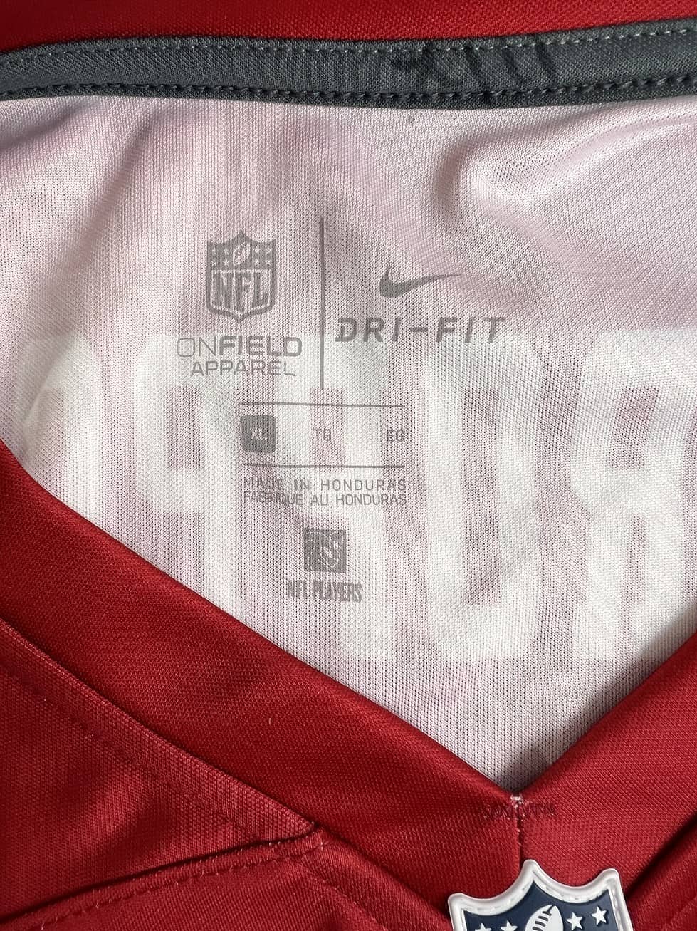 Close-up of the jersey’s tag indicating size XL, made by Nike with Dri-FIT technology, and the NFL’s official merchandise label.