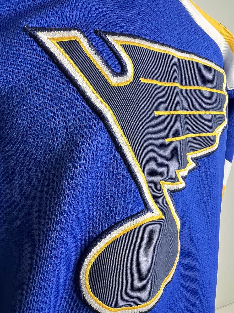 Detail of the jersey’s sleeve showing the St. Louis Blues logo with the team’s winged musical note emblem.