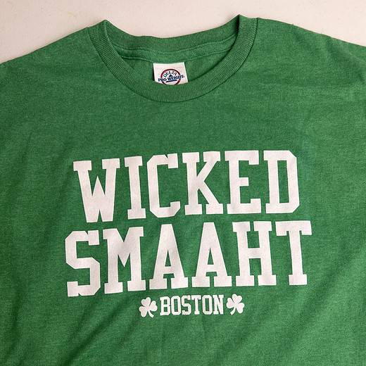 Green t-shirt with 'WICKED SMAAHT BOSTON' printed in bold, white block letters across the front, with two small clover designs on either side of 'BOSTON'.