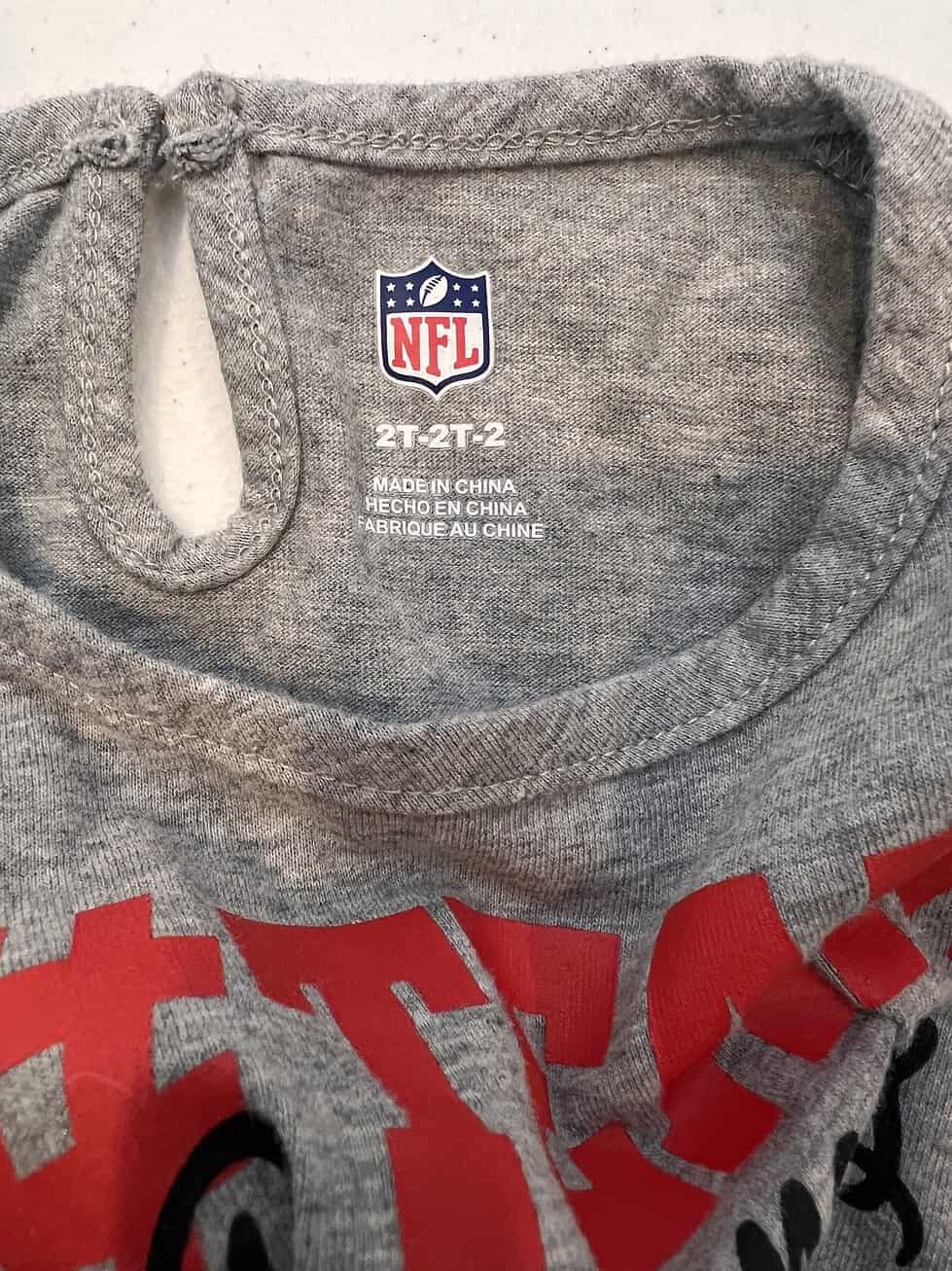 Label of the Tampa Bay Buccaneers toddler dress showing NFL branding and size 2T, made in China.