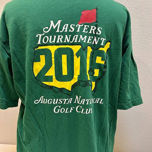 Rear view of the green Masters Tournament t-shirt showcasing the large event logo and "2016 Augusta National Golf Club" text on the back.