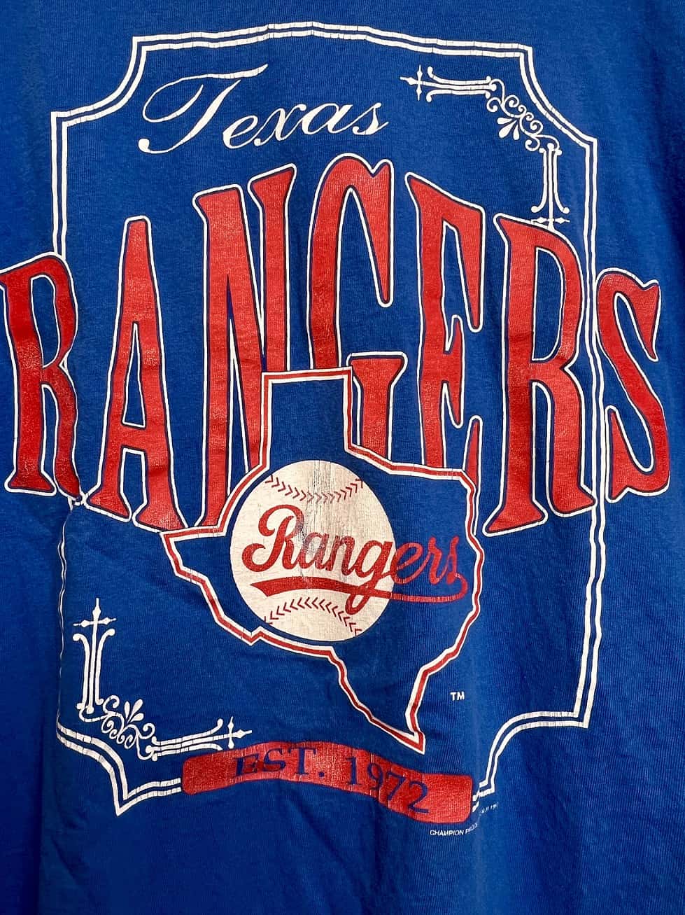 Close-up of Texas Rangers logo with distressed print on royal blue vintage tee