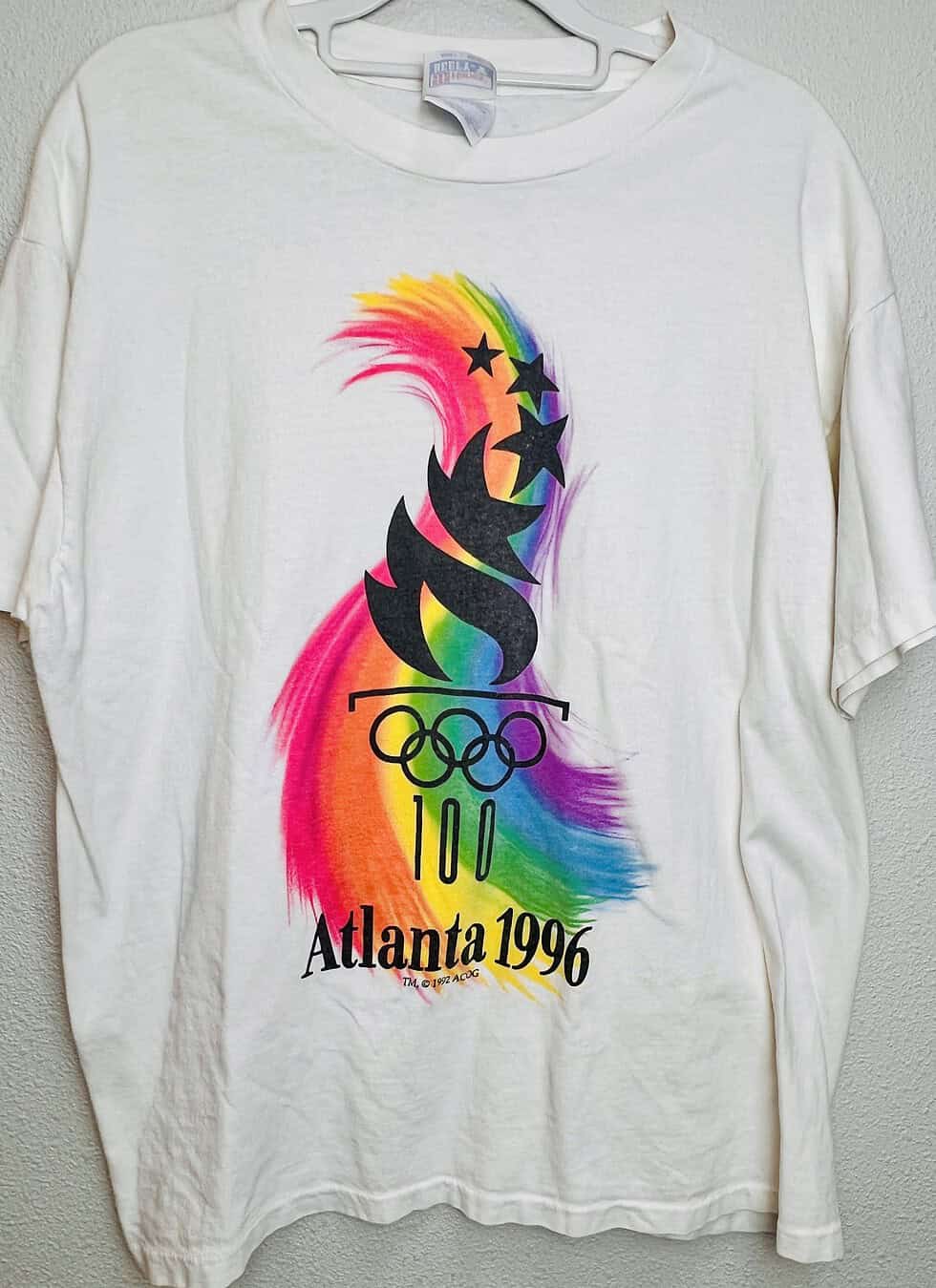 Front view of vintage Atlanta 1996 Olympics tee with rainbow flame design under the Olympics torch and rings logo.