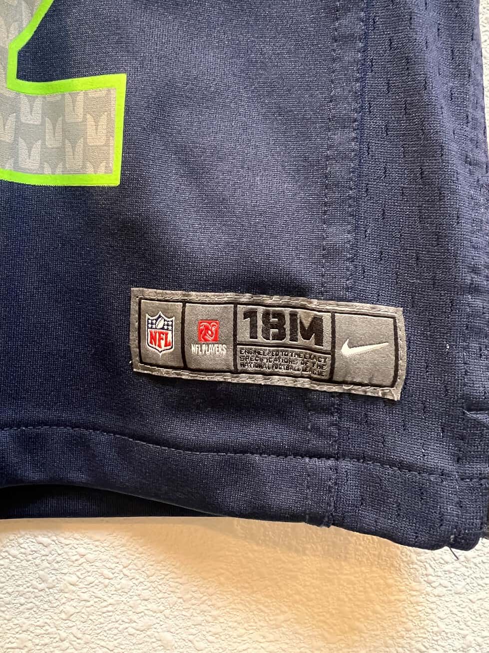 Close-up of the NFL and Nike logos on Seattle Seahawks navy toddler jersey