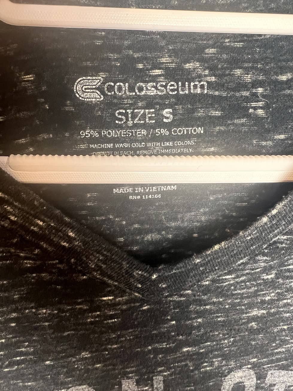 Close-up of Colosseum brand tag showing size small and material details.