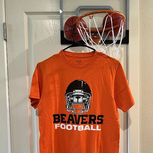 Front view of Oregon State Beavers Football T-Shirt in bright orange, featuring a football helmet graphic.