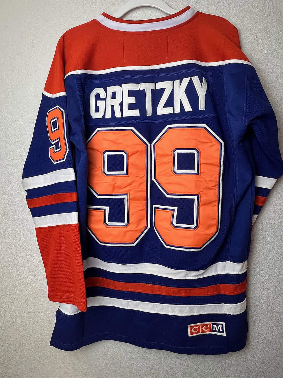Back view of a Wayne Gretzky Edmonton Oilers jersey featuring his iconic number 99 in orange, made by CCM.