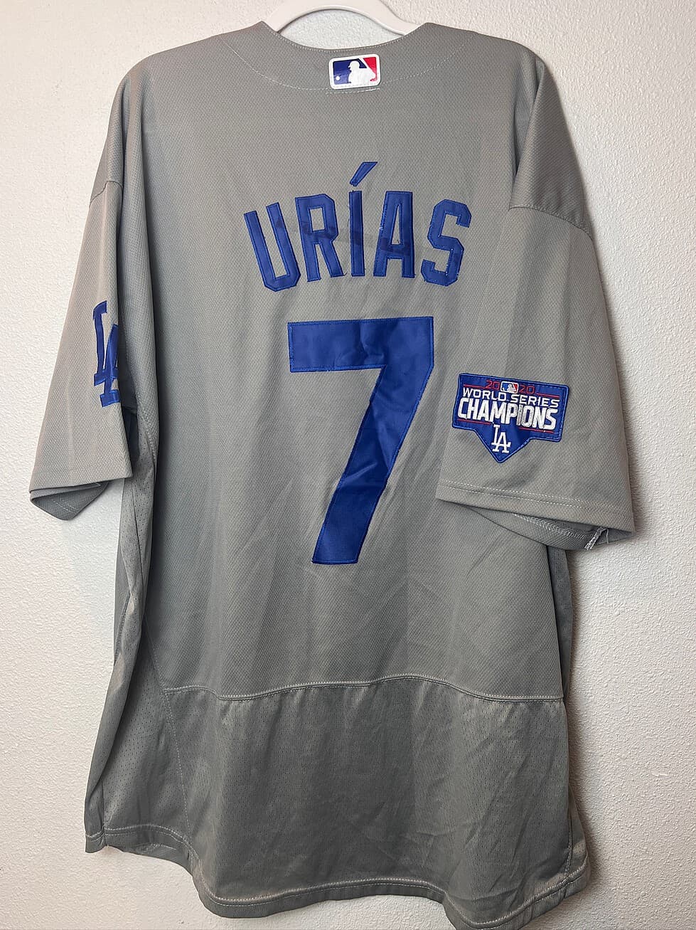 Back view of a gray Los Angeles Dodgers Nike jersey with Julio Urías’ name and number 7, showing the 2020 World Series Champions patch on the sleeve.