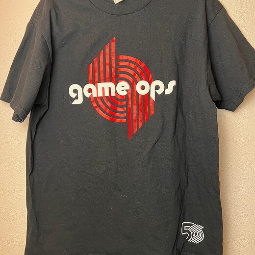 Black Portland Trail Blazers “Game Ops” staff shirt from the 2019-2020 50th anniversary season with red and white logo,