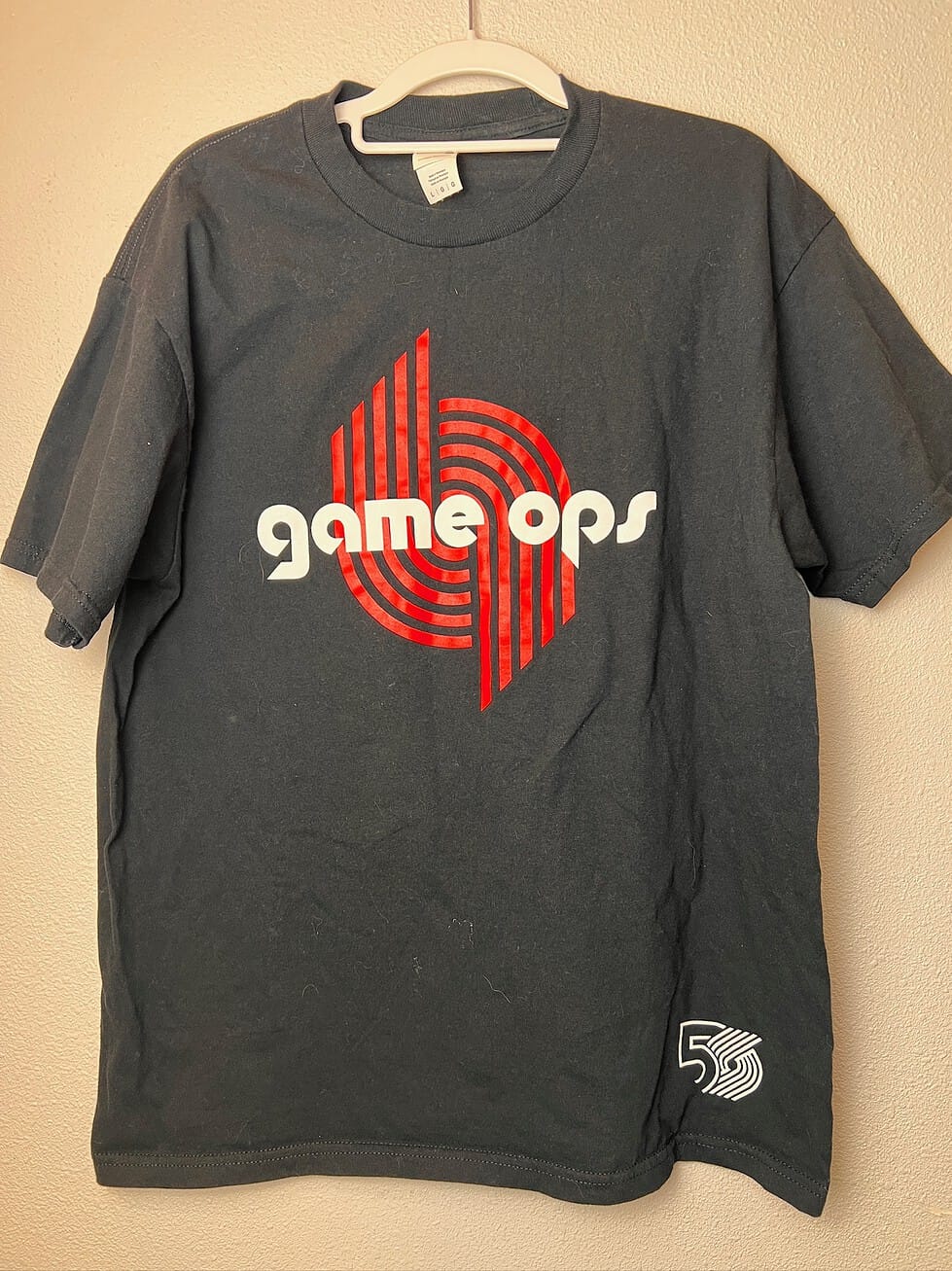 Black Portland Trail Blazers “Game Ops” staff shirt from the 2019-2020 50th anniversary season with red and white logo,