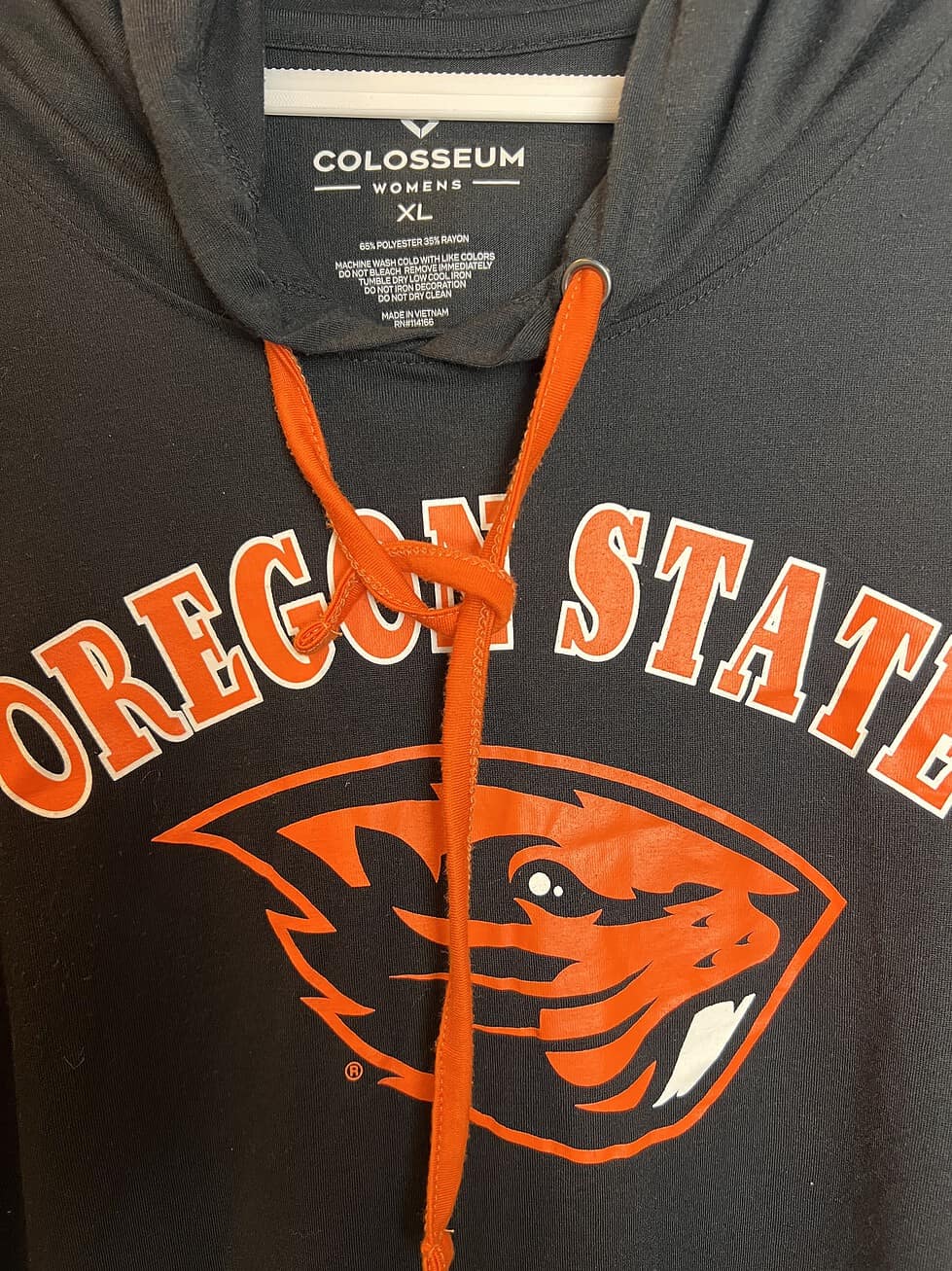 Close-up of Colosseum tag and front graphic, highlighting Oregon State Beavers logo and orange drawstrings.