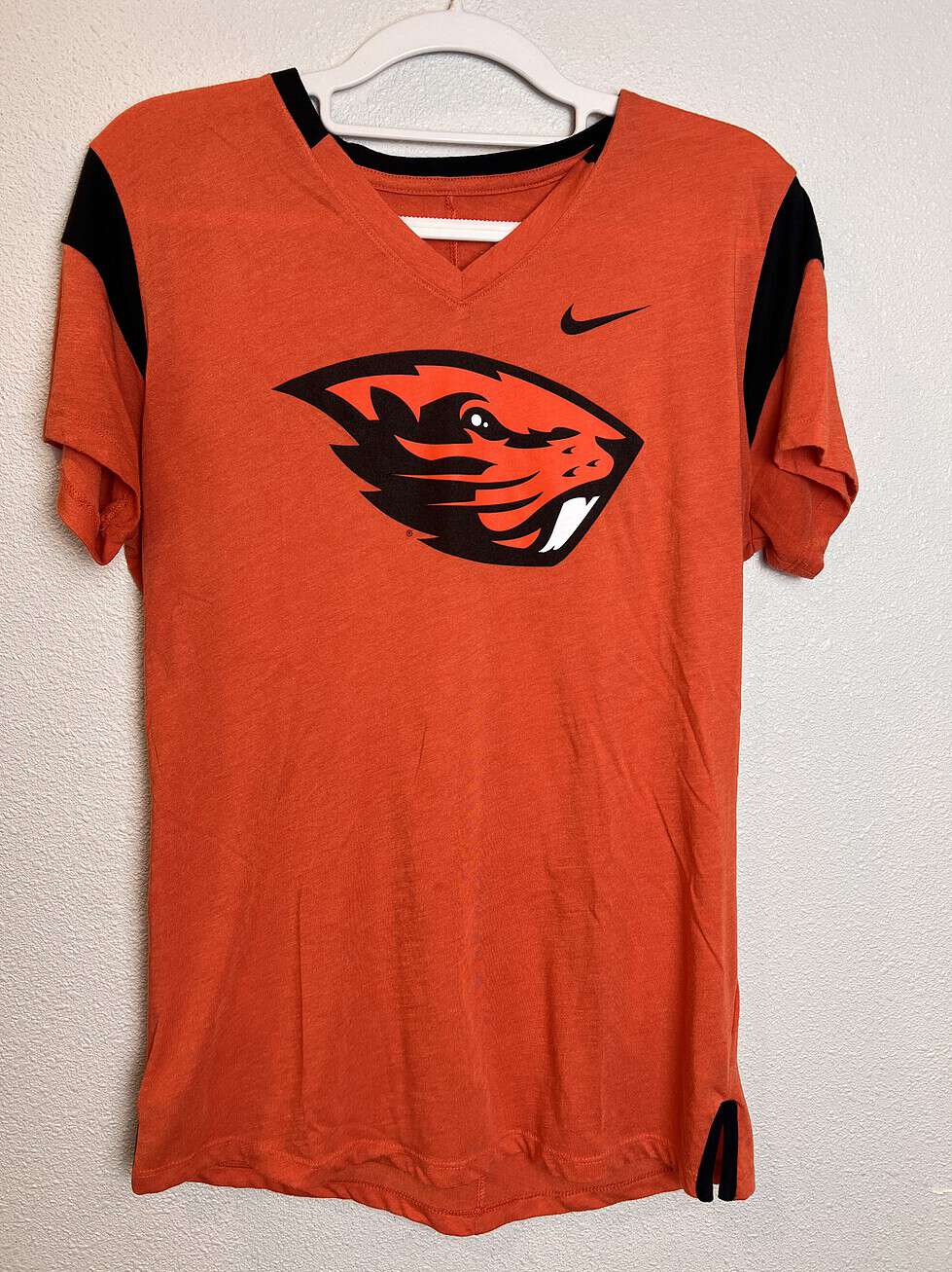 Front view of bright orange Nike Oregon State Beavers V-neck T-shirt with bold logo.