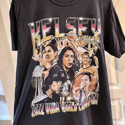 Front view of black Kelsey Plum 2022 WNBA Champion t-shirt featuring images of Plum celebrating the Las Vegas Aces’ victory.