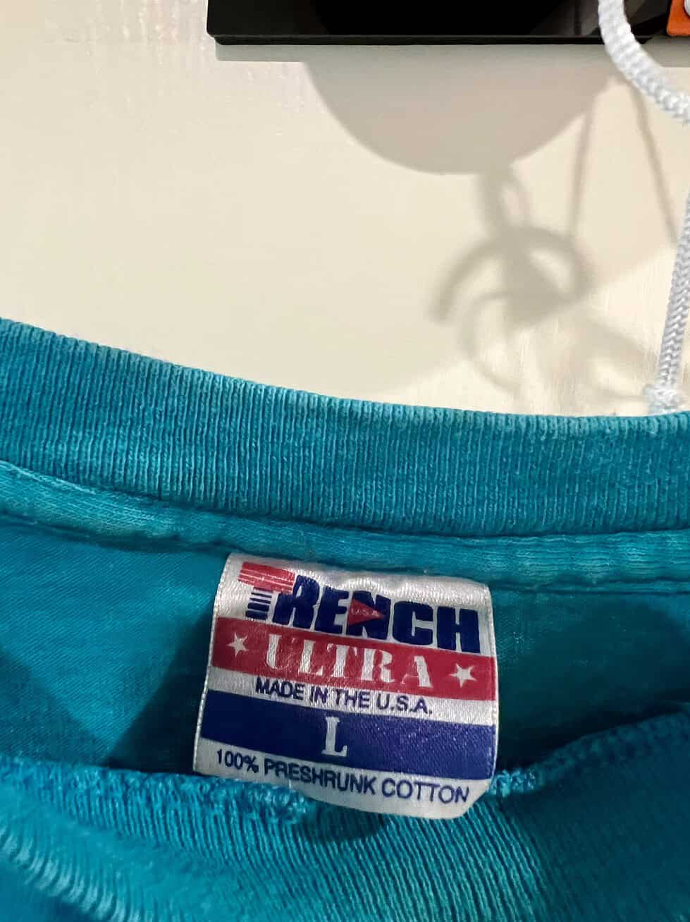 Close-up of the “Trench Ultra” tag inside the vintage San Jose Sharks T-Shirt, size Large