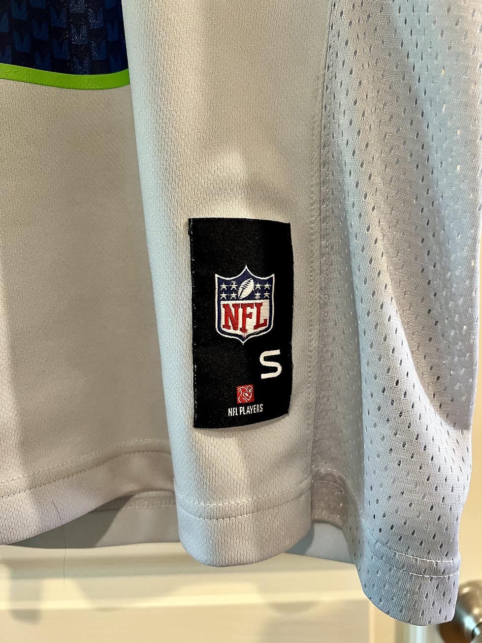 Side view showing NFL logo and size tag on Russell Wilson Seattle Seahawks Jersey.