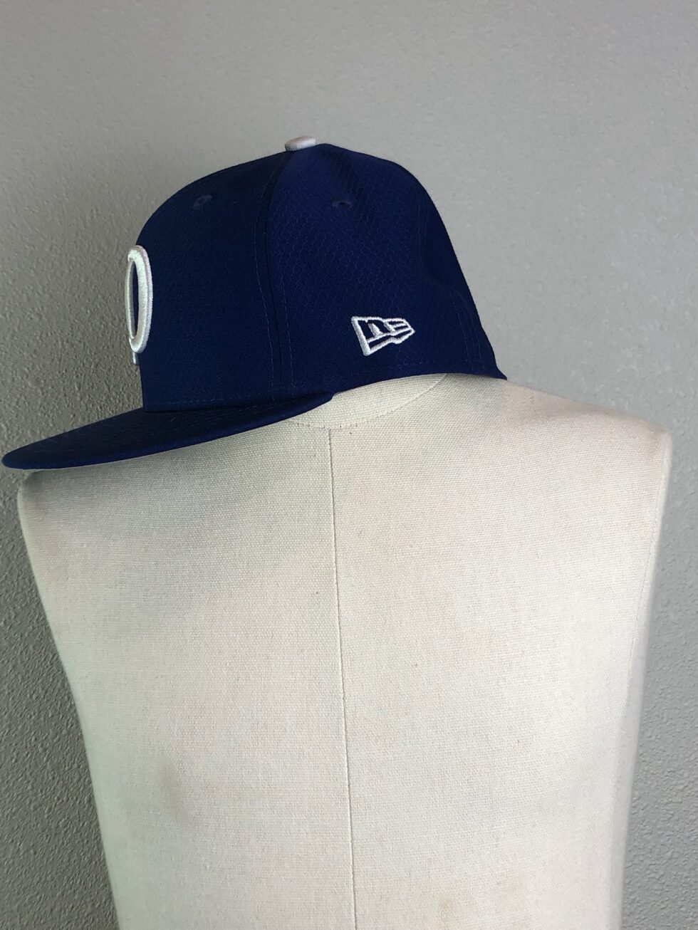 Side profile of Dodgers fitted blue cap showcasing team logo and structured design