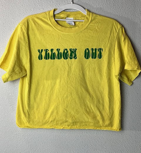 Front view of yellow University of Oregon Ducks t-shirt with “Yellow Out” in green block letters.