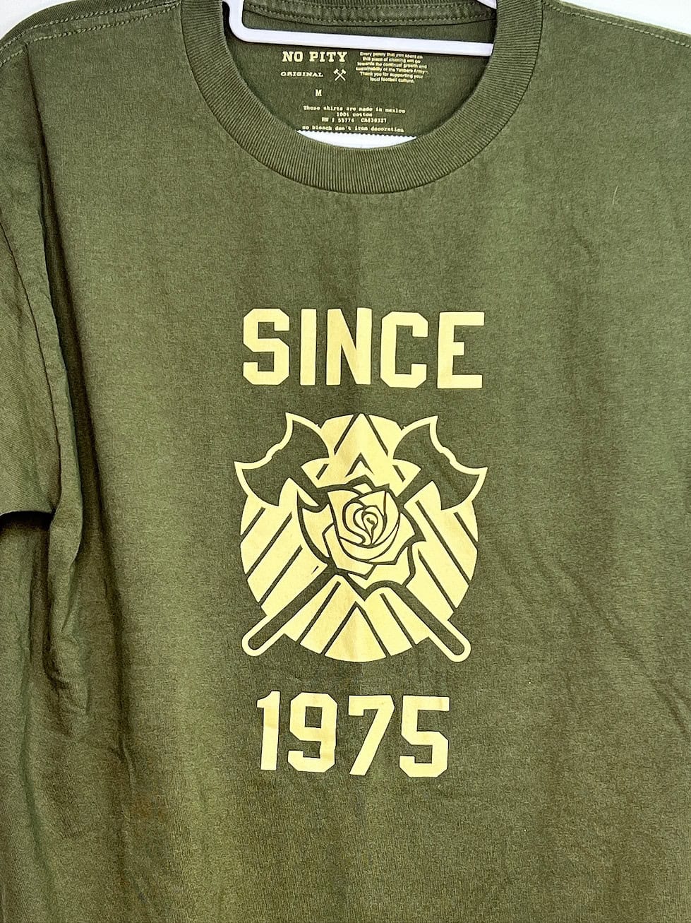 Close-up of 107IST-designed logo and “Since 1975” text on green tee