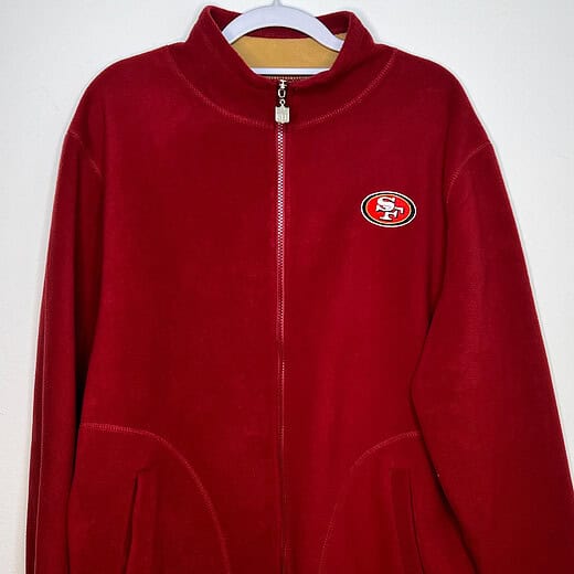 Front of red fleece zip up sweatshirt. Small logo on the upper right