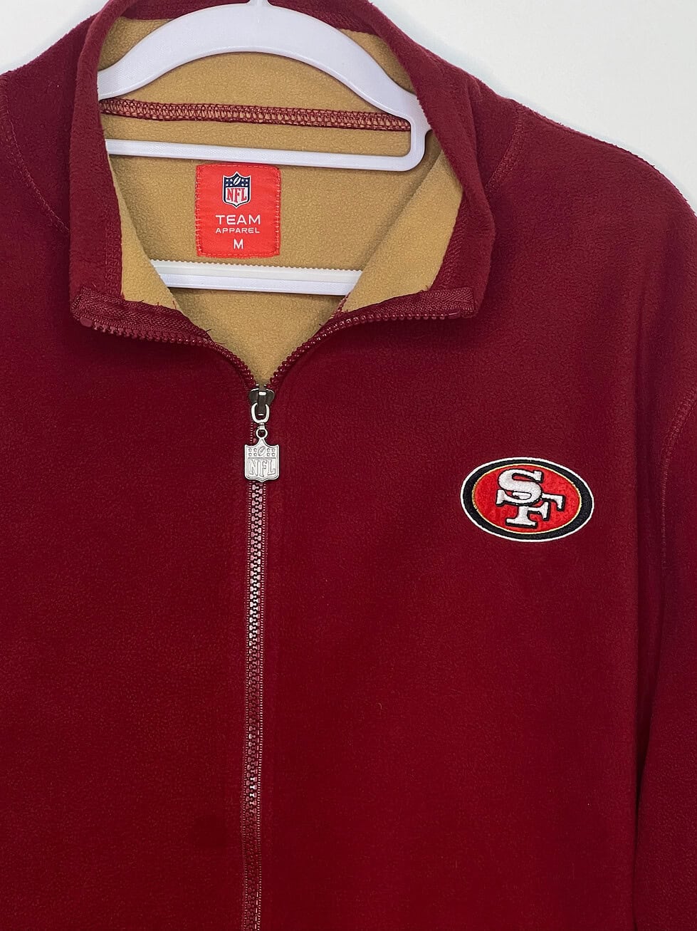 Close up of clothing tag, collar, zipper, and logo