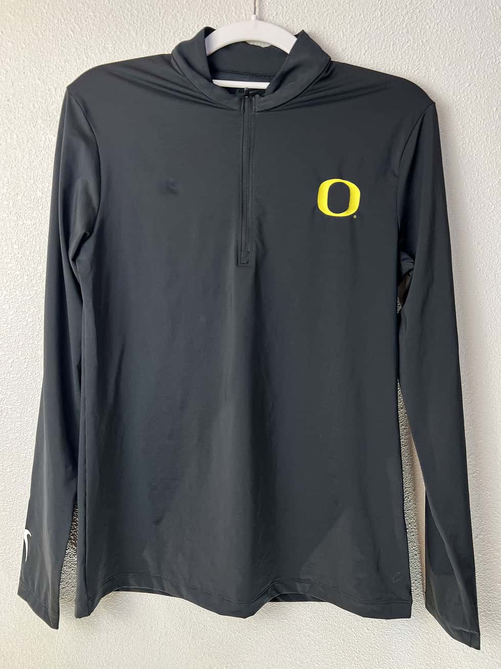 Front view of Nike Oregon Ducks Dri-FIT 1/4 zip polo in black.