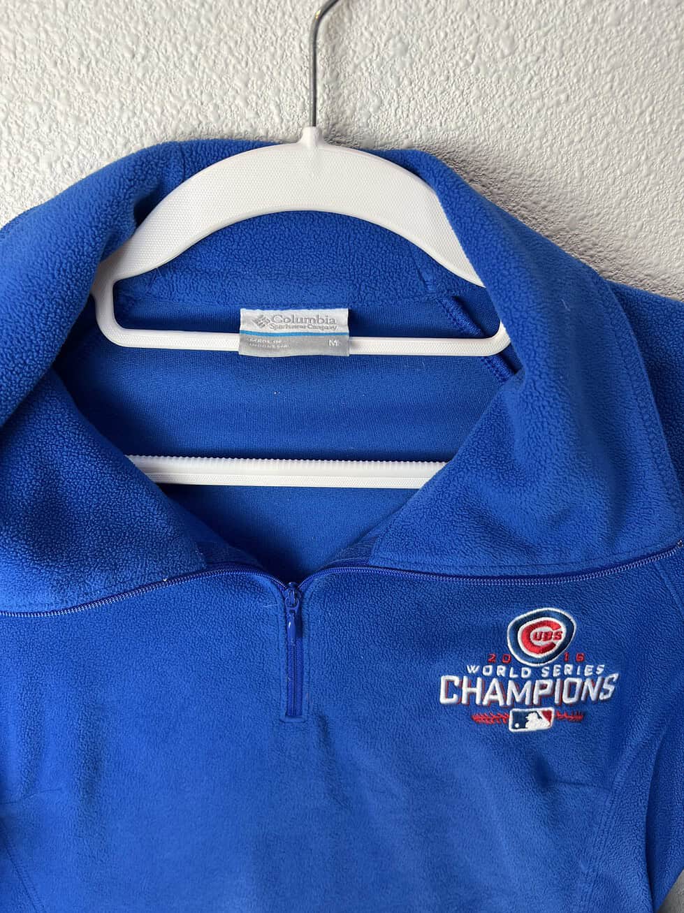 Close-up of embroidered Cubs championship logo on chest.