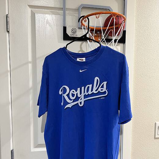 Front view of a blue Nike T-shirt featuring the Kansas City Royals “Royals” script, Adult Medium.