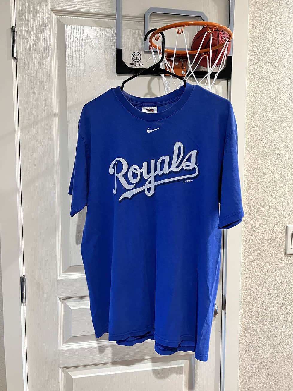 Front view of a blue Nike T-shirt featuring the Kansas City Royals “Royals” script, Adult Medium.