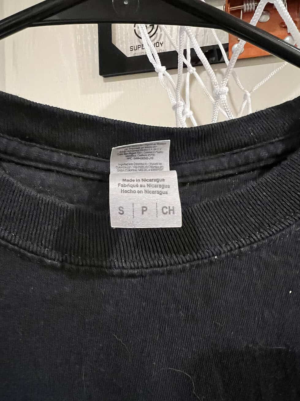 Close-up of the size label (Adult Small) on a black Gildan long-sleeve T-shirt.