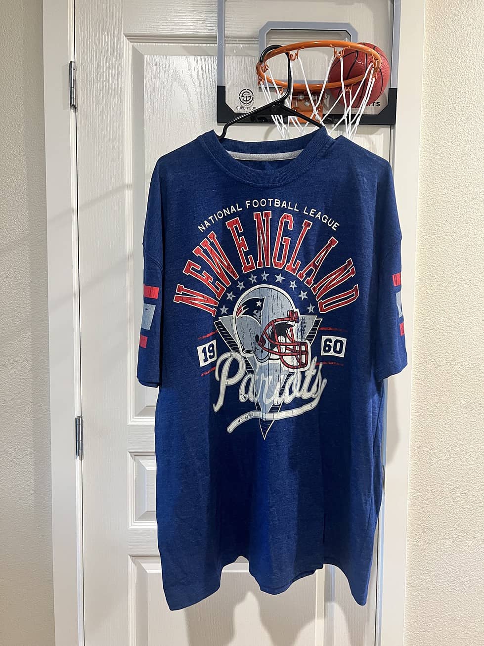 Full front view of a New England Patriots 2XL T-shirt, featuring retro stripes on the sleeves and throwback design.