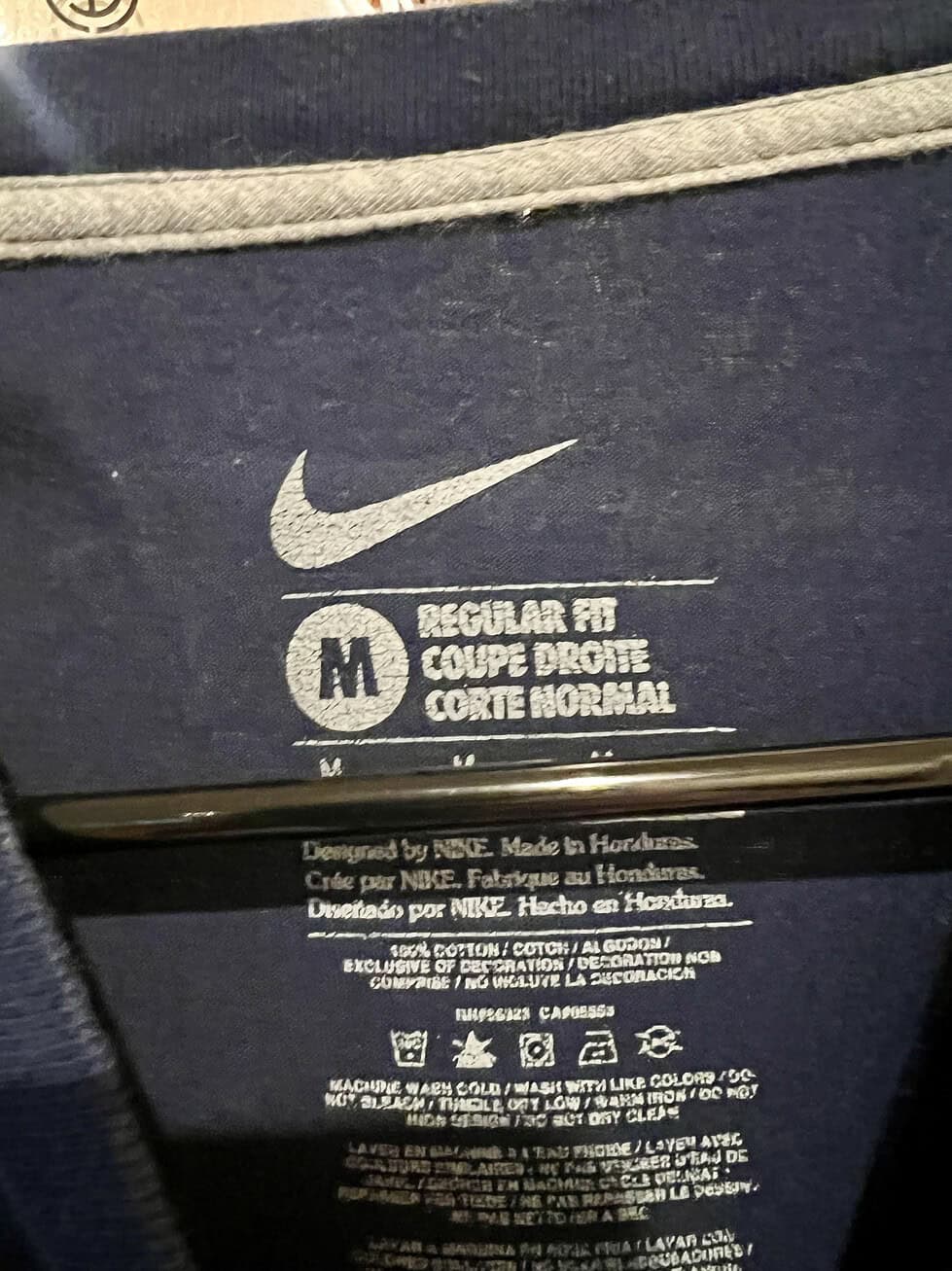 Inner neck label of a Nike Seattle Seahawks T-shirt, showing size Medium and fabric details.