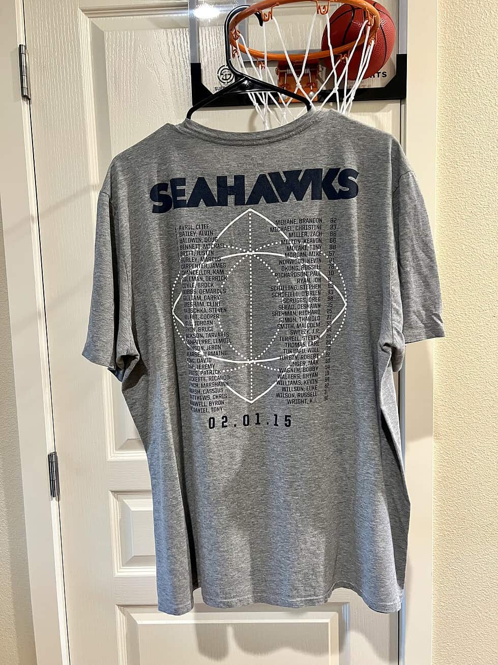 Back view of a gray Seattle Seahawks Super Bowl XLIX T-shirt with roster graphic and game date.
