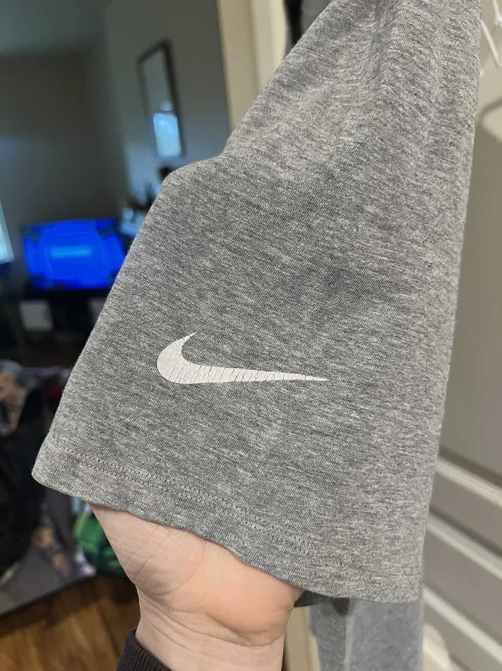 Close-up of the Nike Swoosh on the sleeve of a gray Seahawks T-shirt.
