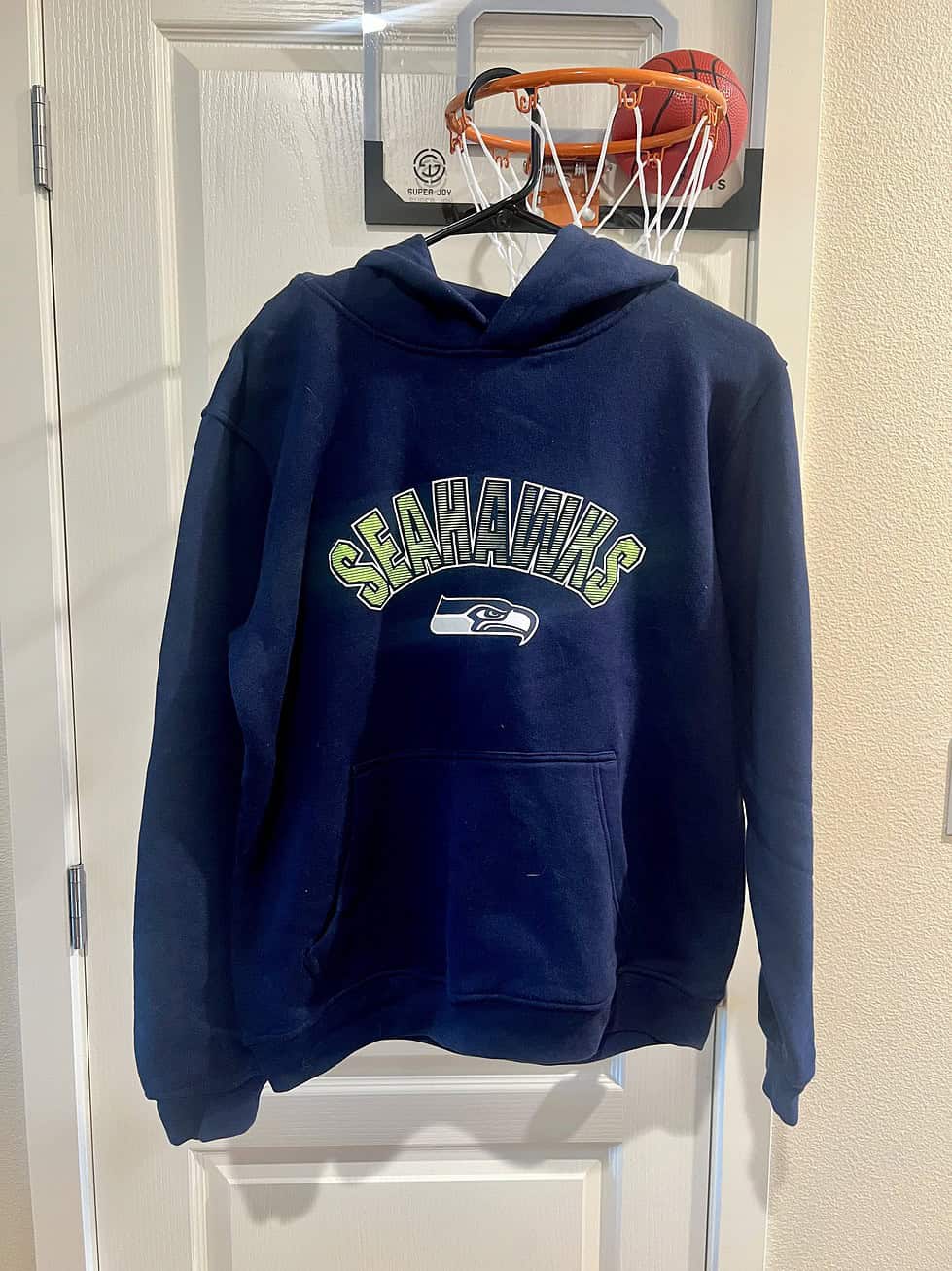 Front view of a navy blue Seattle Seahawks hoodie with green “Seahawks” lettering and team logo.
