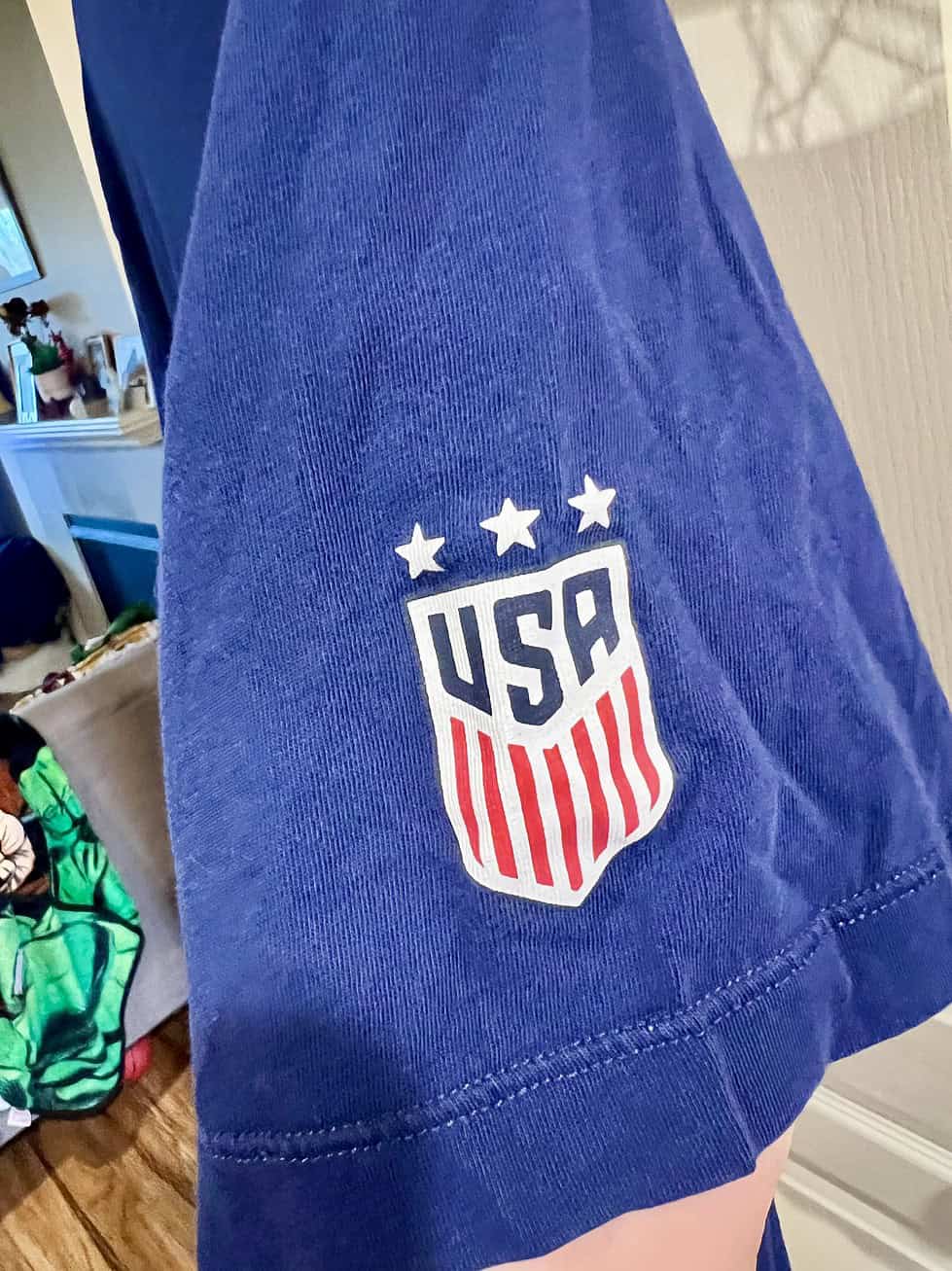 Close-up of USA crest on the sleeve of a navy blue Nike T-shirt.