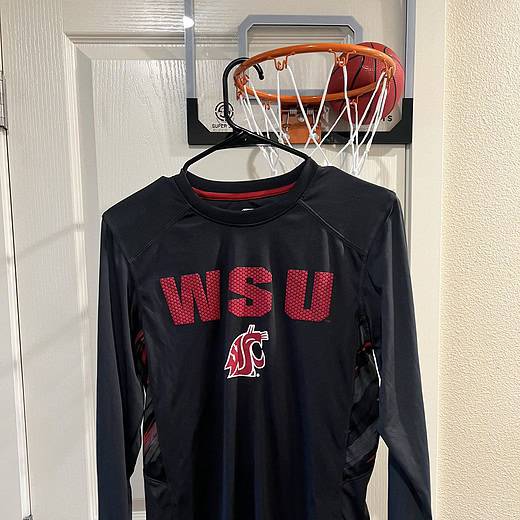 Front view of a black WSU Cougars long sleeve performance shirt with red "WSU" lettering and the Cougars logo.