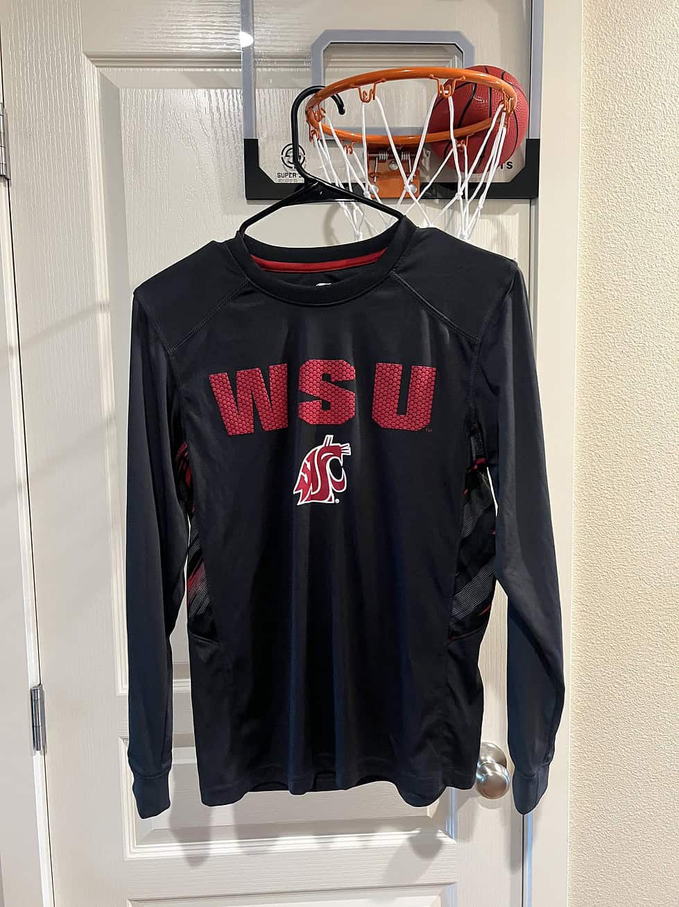 Front view of a black WSU Cougars long sleeve performance shirt with red "WSU" lettering and the Cougars logo.