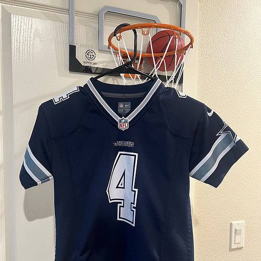 Front view of a Dallas Cowboys Dak Prescott #4 youth jersey in navy blue with silver and white details.