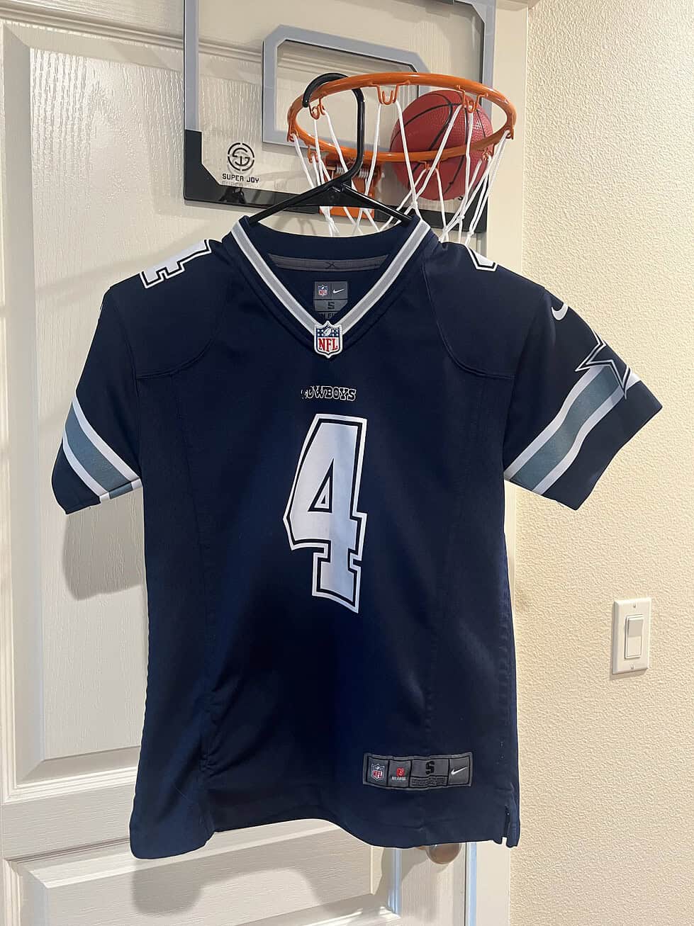 Front view of a Dallas Cowboys Dak Prescott #4 youth jersey in navy blue with silver and white details.