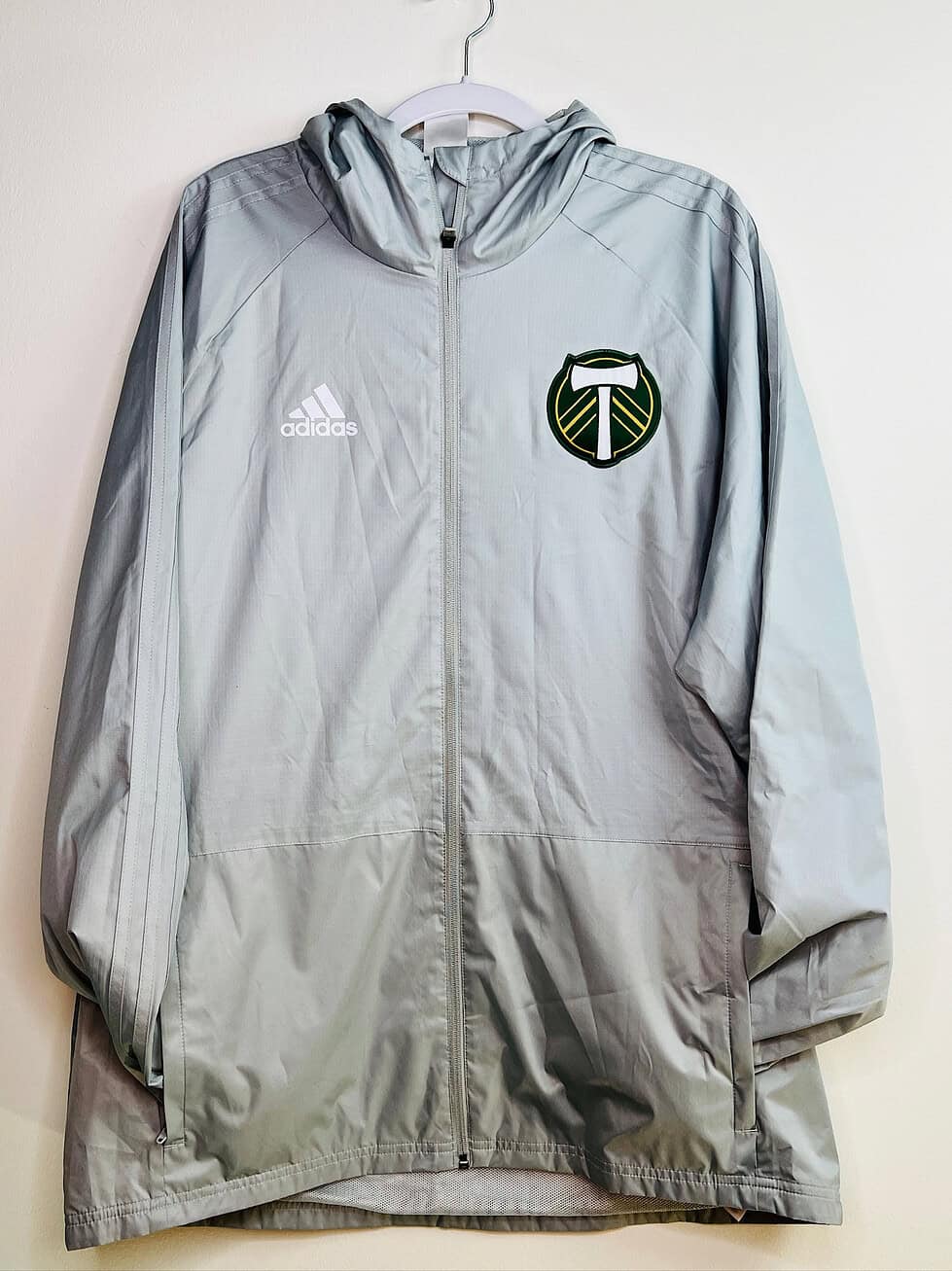 Front view of Portland Timbers Adidas hooded jacket with crest and zipper