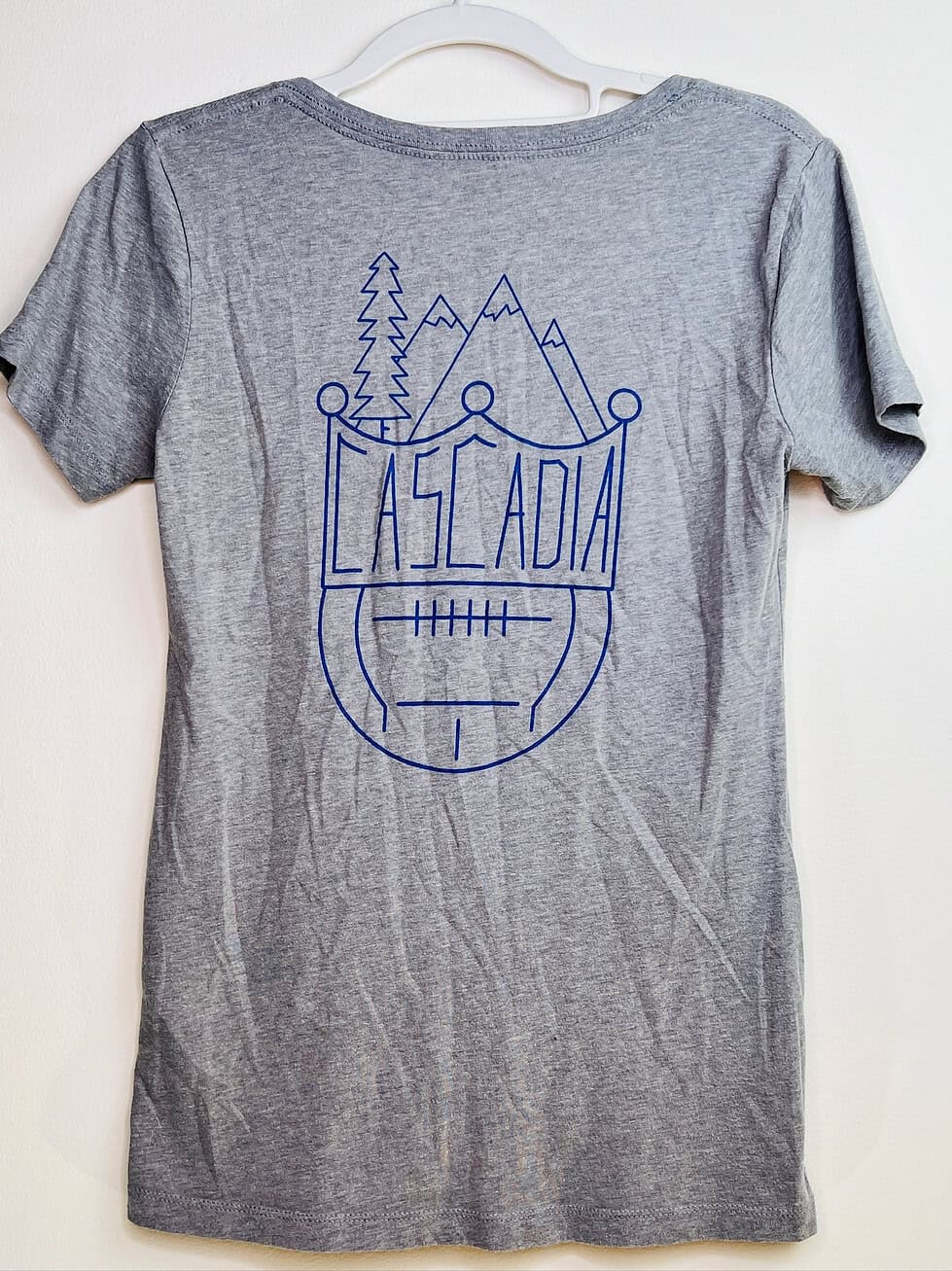 Back view of Cascadia graphic featuring mountains, forest, and soccer ball