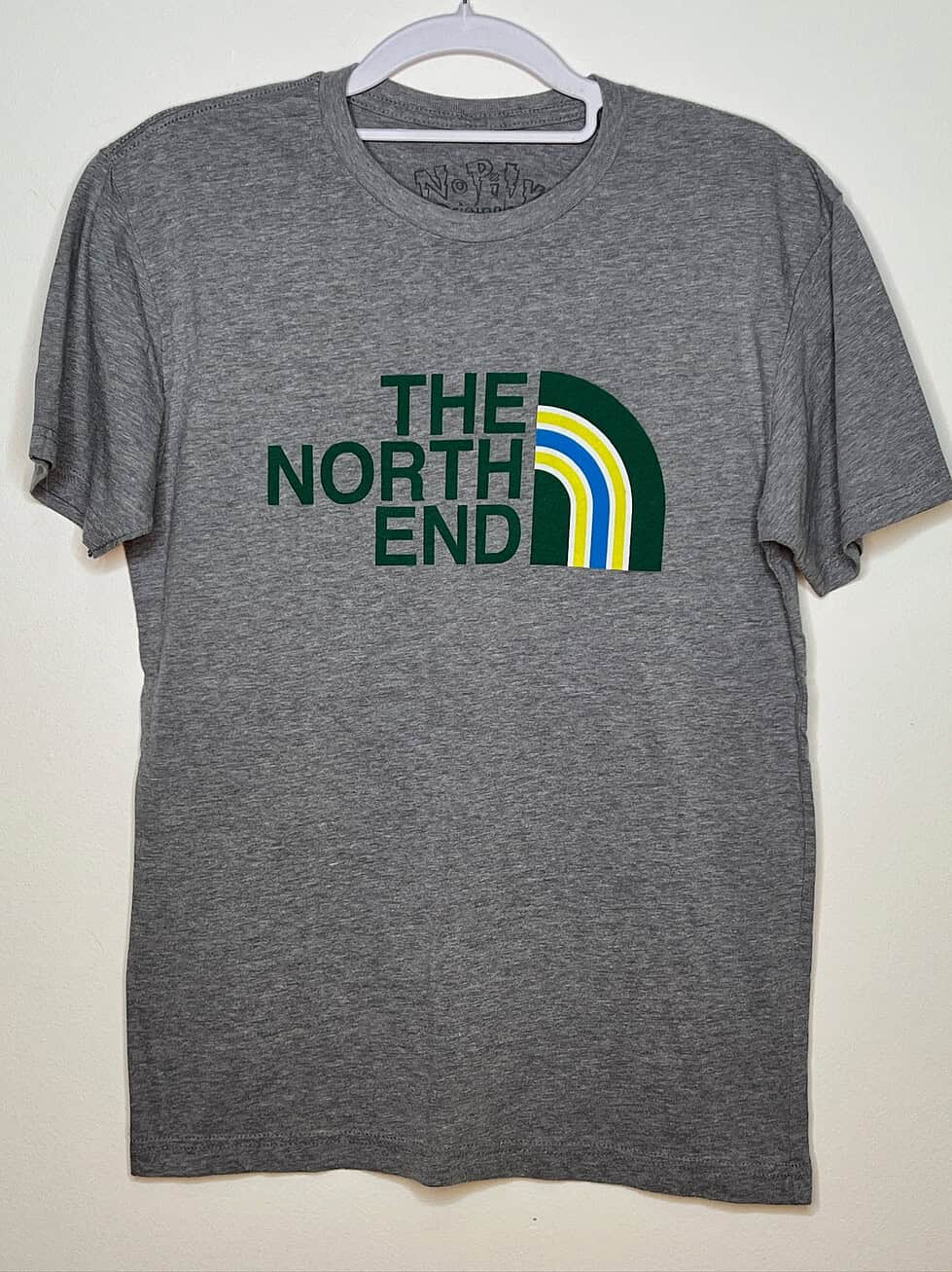 Front of t-shirt. Light heather grey with North Face-style logo in green, yellow, and blue with text replaced with words "The North End"